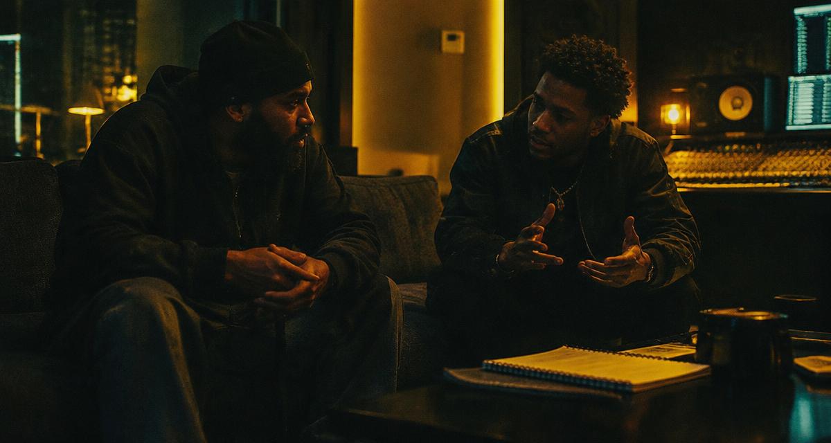 Two independent hip-hop artists planning a guest verse in a recording studio